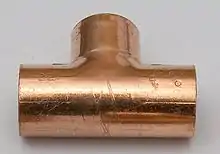 Node in Kirchhoff's junction rule: A pipe tee filled with flowing water.