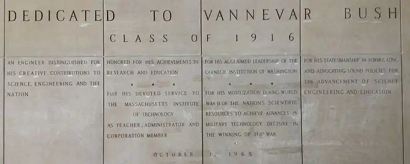Four large panels with words carved in stone. The inscriptions reads: "Dedicated to Vannevar Bush Class of 1916. An engineer distinguished for his creative contributions to science, engineering and the nation. Honored for his achievements in research and education. For his devoted service to the Massachusetts Institute of Technology as teacher, administrator and corporation member. For his acclaimed leadership of the Carnegie Institute of Washington. For his mobilization during World War II of the nation's scientific resources to achieve advances in military technology decisive in the winning of the war. For his statesmanship in formulating and advocating sound policies for the advancement of science, engineering and education. 1 October 1965"