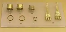 Image 4Finds from an early geometric Cremation Burial of a pregnant wealthy woman, from the N.W. of the Areopagus, about 850 BC, Ancient Agora Museum (Athens); exhibit 14–16: broad gold finger rings; exhibit 17–19: gold finger rings; 20: pair of gold earrings with trapezoid endings (from Greek Dark Ages)