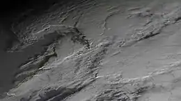 Desaturated image of cloud as viewed from above; they appear grey and are slightly elevated in the image