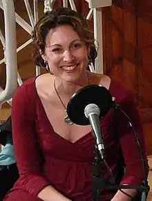 Bazelon sits at a microphone