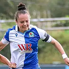 woman footballer, in white and blue of Blackburn