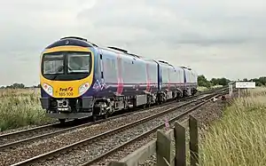 A three-car diesel train passing over a railway junction