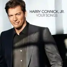 Harry Connick Jr. in a black jacket and black shirt, white background, black text