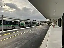 Bus interchange road with bus stops and a group of buses parked on the other side