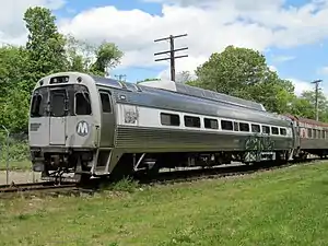 A silver railroad coach on a siding