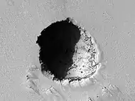 HiRISE image of a 180 m wide lava tube skylight on the southeast flank of Pavonis Mons.