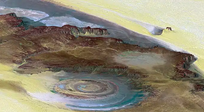 Image 72The Richat Structure is a depression in the country of Mauritania, almost 50 km (30 mi) across. It was originally thought to be the impact of a meteorite. Now it is thought to be a symmetrical uplift (circular anticline or dome) that has been exposed to erosion. In this false-color photo, bedrock is brown, sand is yellow and white, vegetation is green, and salty sediments are blue. (Credit: Landsat 7.) (from Portal:Earth sciences/Selected pictures)