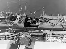 USS Lakehurst (formerly Seatrain New Jersey), after discharging medium tanks at Safi, Morocco. Load is damage plane to be repaired.