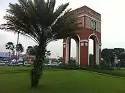 An arch and a palm tree near a shopping center