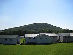 Sugarloaf Mountain viewed from the nameless hill above Elkview, with camp buildings in the foreground.