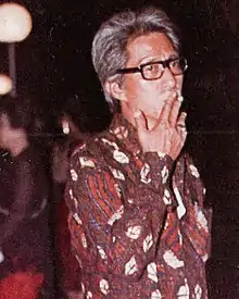 Film director Teguh Karya, standing with a cigarette in his mouth