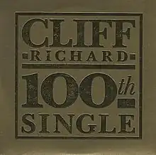 CD single sleeve showing a gold background with embossed gold letters 'Cliff Richard 100th Single'