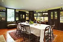The dining room of the Florence Griswold House in Old Lyme, CT showcasing painted wall panels by 19th century American artist-boarders.